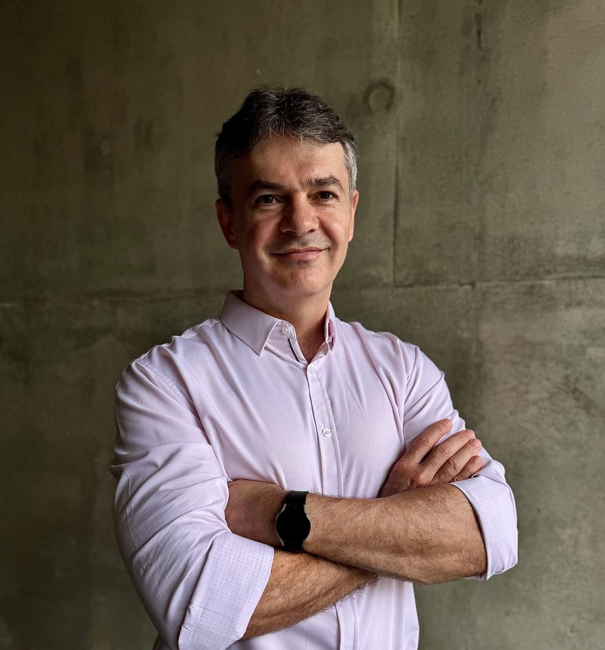Edu van Zyl, founder of Connected Strategies, in a light shirt with arms crossed, photographed against a concrete wall.